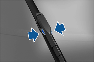Close-up of wiper blade with two blue arrows pointing to tabs